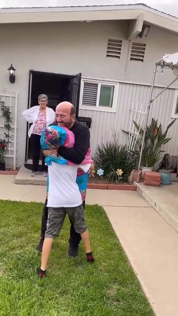 Grandpa Uses Plastic Sheet as Social Distancing Shield While Hugging Grandson