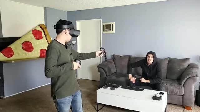 Guy Playing Virtual Reality Game Screams Scaring Off Friend Sitting on Couch