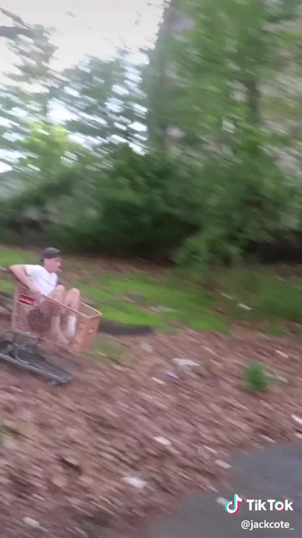 Guy Sitting in Shopping Trolley Slides on Downslope and Falls Hard on Road