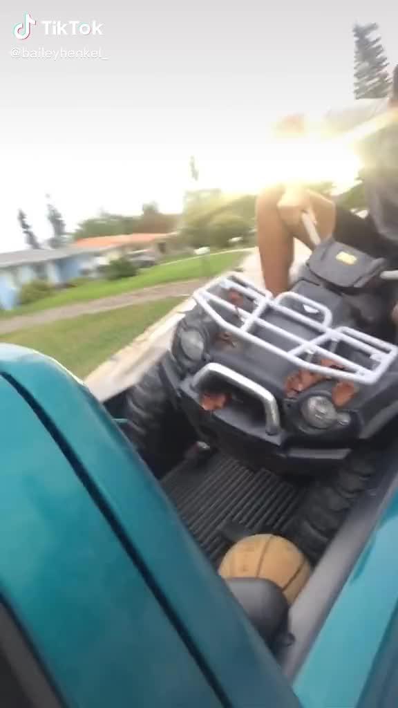 Guy Sitting on ATV Goes Overboard and Falls on Ground From Moving Pickup Truck