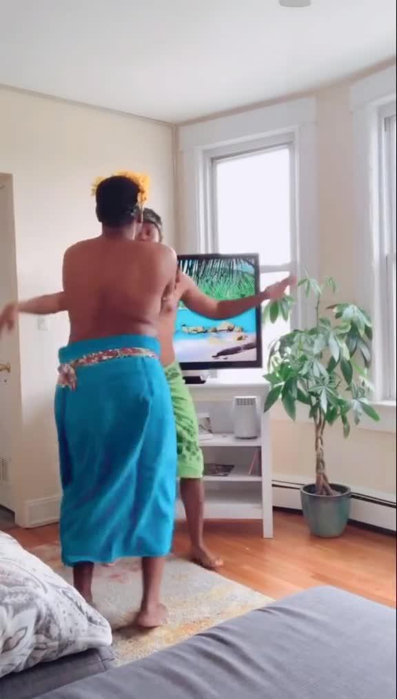 Two Men Wearing Towels do Hula Dance in Their Living Room While Sheltering in Place